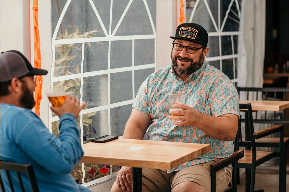 Customers smiling and enjoying drinks at Arable Brewing Company