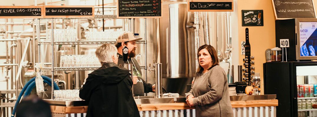 Amy and Cam Wells helping a customer at Arable Brewing Company