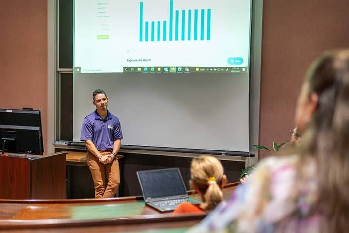 College professor takes questions from students while presenting LivePlan's reporting dashboard feature.