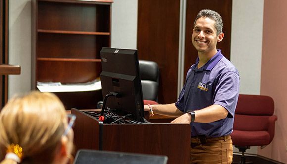 Corey, a college professor presenting from the podium in front of the class.