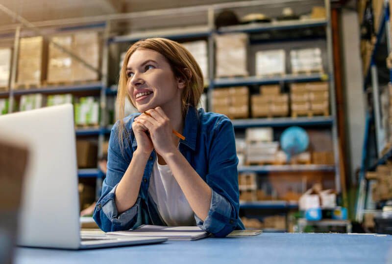 Woman smiling and working on laptop