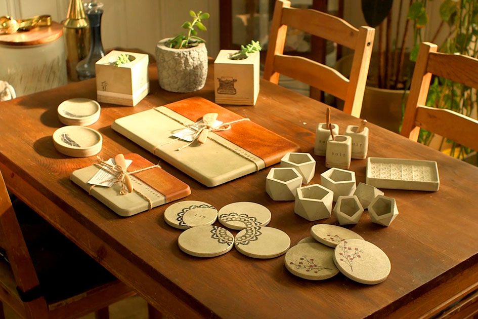 Mona's concrete homewares, including cheese boards, coasters, and vases.