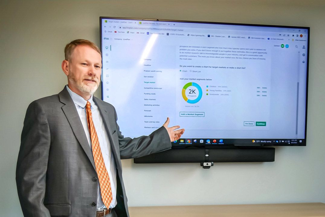 Clemson Small Business Development Center Area Manager Ben Calhoun pointing to the LivePlan dashboard.